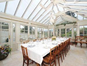 uma sala de jantar com uma mesa longa e cadeiras em Luxury Country House Glendalough Wicklow em Laragh