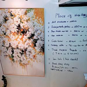 ein Bild von Blumen, die an einer Wand hängen in der Unterkunft 134 Lily's Sweet Green and White in Dist 1 in Ho-Chi-Minh-Stadt