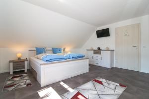 a bedroom with a white bed with blue pillows at Ferienwohnungen Gatena in Norddeich