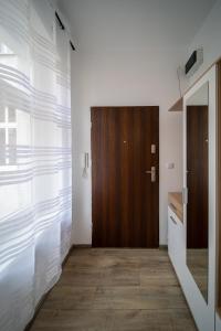 un couloir avec une porte et une porte en bois dans l'établissement Jungle Vision Apartment - Rynek, à Carolinensiel