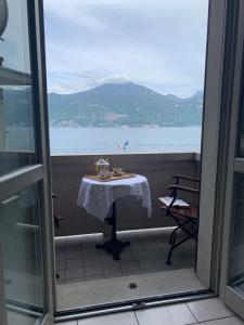 a table on a balcony with a view of the ocean at Zippity Doo Dah - Menaggio Home - Como Lake in Menaggio