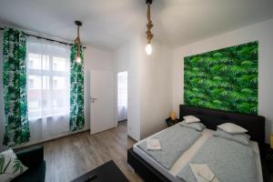 - une chambre avec une grande peinture verte sur le mur dans l'établissement Jungle Vision Apartment - Rynek, à Carolinensiel