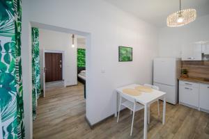 - une cuisine et une salle à manger avec une table dans l'établissement Jungle Vision Apartment - Rynek, à Carolinensiel