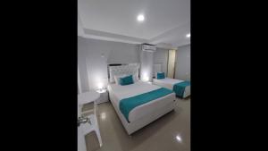 1 Schlafzimmer mit 2 Betten, einem Tisch und einem Schreibtisch in der Unterkunft Bm-17 Charming Cartagena Lodge with Shared Pool Terrace in Cartagena de Indias