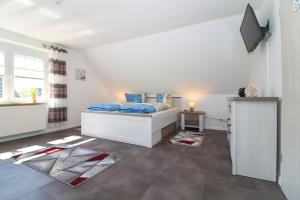 1 dormitorio con 1 cama y TV en Ferienwohnungen Gatena, en Norddeich