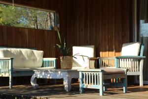 a group of chairs and a coffee table on a porch at Wooden house by the sea in Hourtin