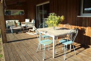 a wooden table and chairs on a deck at Wooden house by the sea in Hourtin