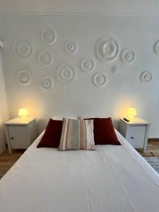 una camera da letto con un grande letto bianco con due comodini di Les Enfants Terribles a Villeneuve-lès-Béziers