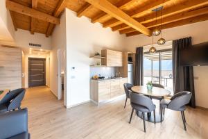 een keuken en eetkamer met een tafel en stoelen bij Evo Suites Apartments in Limone sul Garda
