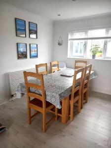 a dining room table with chairs and a table and a table and chairsktop at Amazing Beach House, Sleeps 8, Pet Friendly in Trearddur