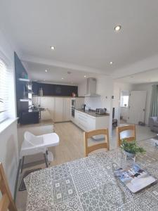 a kitchen and living room with a table and chairs at Amazing Beach House, Sleeps 8, Pet Friendly in Trearddur