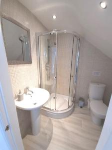 y baño con ducha, lavabo y aseo. en Amazing Beach House, Sleeps 8, Pet Friendly, en Trearddur