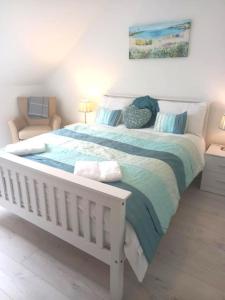 a bedroom with a white bed with a blue blanket at Amazing Beach House, Sleeps 8, Pet Friendly in Trearddur +18 photos