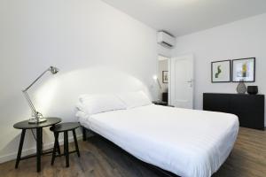 a bedroom with a large white bed and a table at Nen&egrave; - La Scalinata apartments in Bellagio