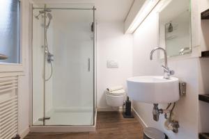 a bathroom with a shower and a sink and a toilet at Nen&egrave; - La Scalinata apartments in Bellagio