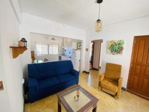 エルミグアにあるLightbooking Hermigua vista al mar y al Teideのリビングルーム(青いソファ、椅子付)
