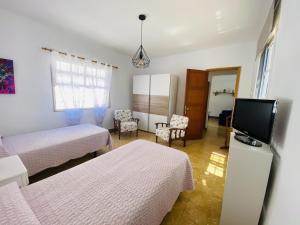 a bedroom with two beds and a flat screen tv at Lightbooking Hermigua vista al mar y al Teide in Hermigua