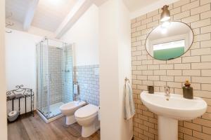 a bathroom with a sink and a toilet and a mirror at Dimora Campo delle Mura - Charming House in Acquaviva Picena