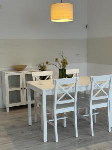Biały stół i krzesła w kuchni w obiekcie City Center Accommodation 111 w mieście Reşiţa