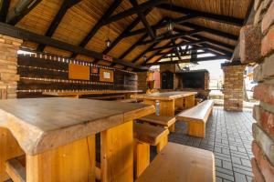 a bar with wooden tables and benches in a building at San Marco - Na Brněnské ulici in Mutěnice
