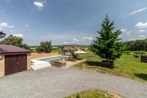 a backyard with a swimming pool and a tree at San Marco - Na Brněnské ulici in Mutěnice