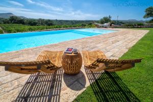 una mesa y sillas junto a una piscina en Tenute Shardana Luxury Farmhouse with SPA, Sauna, Heated Swimming Pool en Mores
