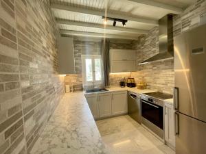 a kitchen with white appliances and a brick wall at Infinity View Villas Mykonos in Kalo Livadi