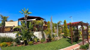 una casa con un jardín con árboles y plantas en Paraíso del Valle, en Ensenada