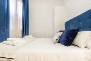 a white bed with blue curtains and towels on it at Central apartment by Picasso Museum by REMS in Málaga
