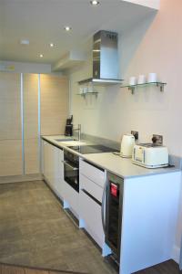 cocina con encimera, tostadora y electrodomésticos en Penthouse in Old Street, en Londres