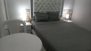 a bedroom with a bed with a headboard and a chair at Bm-6 room near the sea with air conditioning and WIFI in Cartagena de Indias