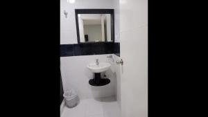 a white bathroom with a sink and a mirror at Bm-6 room near the sea with air conditioning and WIFI in Cartagena de Indias +3 photos