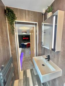 W łazience znajduje się umywalka, lustro i stół. w obiekcie Coastline Retreats - Cloud9 Newly Renovated, Beautiful Ensuite Rooms Near Seafront in Town Centre, Netflix, SuperFast WiFi, Communal Kitchen w Bournemouth
