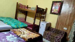 Habitación con 2 literas y escritorio. en Hotel Golden Crown Laxman Jhula, en Rishīkesh
