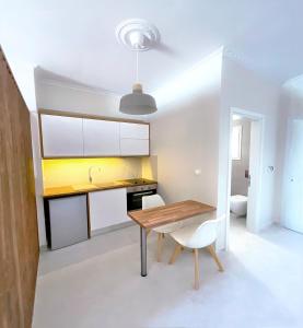 a kitchen and dining room with a wooden table and chairs at Beachfront 2-bed luxury Apartment - Agios Gordios Corfu Greece in Agios Gordios