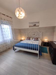 a bedroom with a bed and a chandelier at Appartamento vicino Grado/Aquileia in San Lorenzo