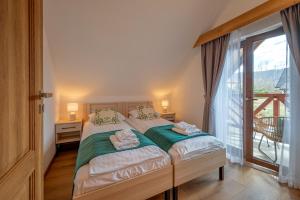 1 dormitorio con cama y ventana grande en Apartamenty Otulina, en Wetlina