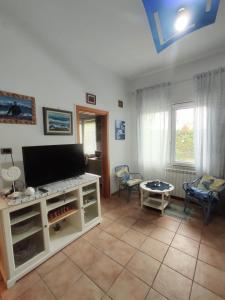 un soggiorno con TV e tavolo di Appartamento vicino Grado/Aquileia a San Lorenzo