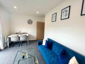 uma sala de estar com um sofá azul e uma mesa em Lorne Park Road, Bournemouth em Bournemouth