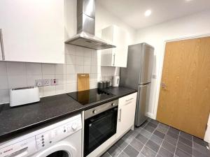 uma cozinha com um frigorífico e uma máquina de lavar e secar roupa em Lorne Park Road, Bournemouth em Bournemouth