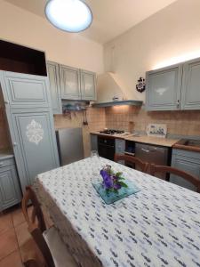 una cucina con tavolo e fiori viola di Appartamento vicino Grado/Aquileia a San Lorenzo