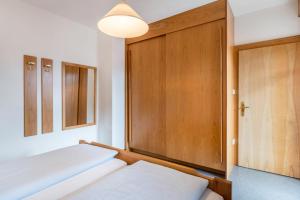 1 Schlafzimmer mit 2 Betten und einer Holztür in der Unterkunft Taufner Apartement C 103 in Partschins
