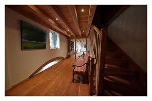 a hallway of a house with a staircase and a chair at LES CHAMBRES DE LIANE in Cerdon