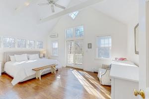 Edgartown Retreat في إدغارتاون: غرفة نوم بيضاء مع سرير كبير ونوافذ