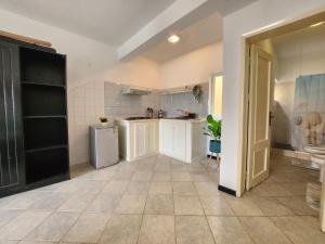 a large kitchen with white cabinets and a refrigerator at COZY STUDIO CLOSE TO THE BEACH! in Santa Maria