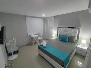 a bedroom with a large bed with blue pillows at Bm-9 room near the sea with air conditioning and WIFI in Cartagena de Indias