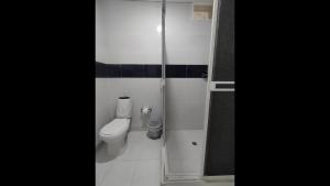 a bathroom with a toilet and a glass shower at Bm-1 room near the sea with air conditioning and WIFI in Cartagena de Indias +4 photos