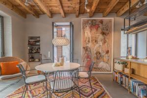 ein Esszimmer mit einem Tisch, Stühlen und einem Gemälde in der Unterkunft Casa Stella in Varenna