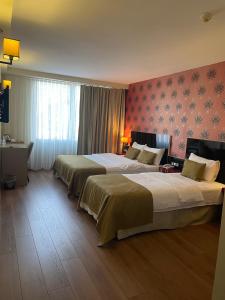 een hotelkamer met 2 bedden en een raam bij Era Palace Hotel in Istanbul
