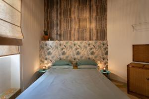 a bedroom with a bed with a headboard and two lamps at Authentic Maltese 2-bedroom House with Terrace in Żejtun